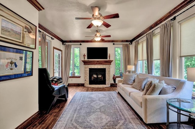 10035 Stone Gate Way, Arcadia, OK 73007 - living area with ceiling fan, dark wood finished floors, a fireplace with raised hearth, and crown molding