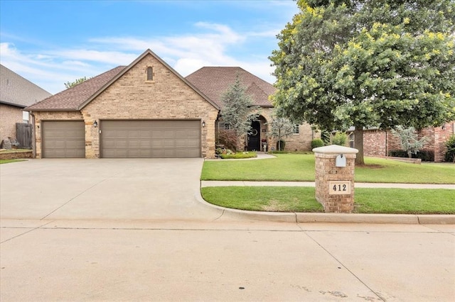412 Swingman Rd, Yukon, OK 73099 - view of front of property with concrete driveway, a garage, a front lawn, brick siding, and roof with shingles
