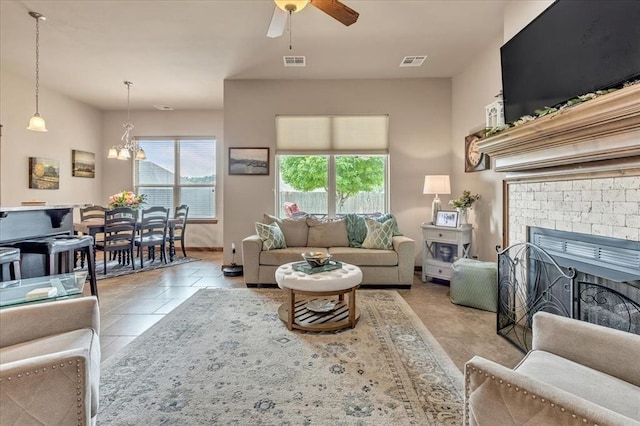 412 Swingman Rd, Yukon, OK 73099 - living area featuring a ceiling fan, a chandelier, a fireplace, and light tile patterned floors