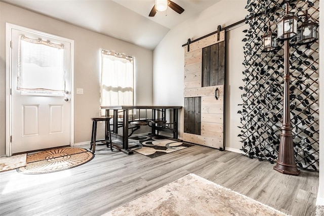 9920 Black Bear Trl, Yukon, OK 73099 - foyer entrance featuring a barn door, wood finished floors, ceiling fan, and vaulted ceiling