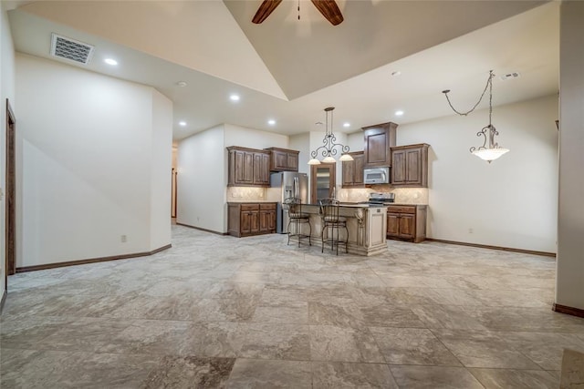 2216 SW 117th St, Oklahoma City, OK 73170 - kitchen featuring appliances with stainless steel finishes, a kitchen bar, a ceiling fan, decorative backsplash, and recessed lighting