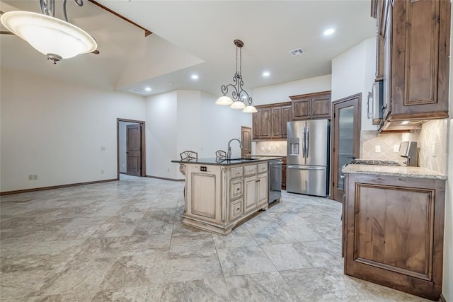 2216 SW 117th St, Oklahoma City, OK 73170 - kitchen featuring appliances with stainless steel finishes, tasteful backsplash, recessed lighting, a center island with sink, and pendant lighting