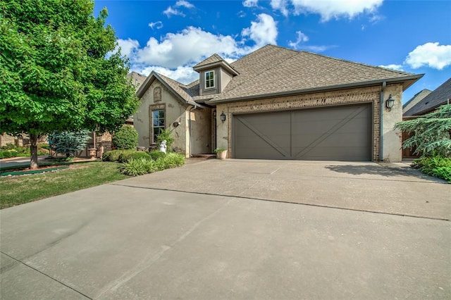 2216 SW 117th St, Oklahoma City, OK 73170 - view of front facade with concrete driveway, an attached garage, brick siding, and stucco siding