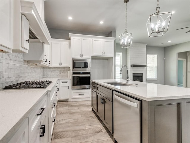 8520 NW 123rd St, Oklahoma City, OK 73142 - kitchen with stainless steel appliances, an island with sink, white cabinetry, decorative backsplash, and recessed lighting