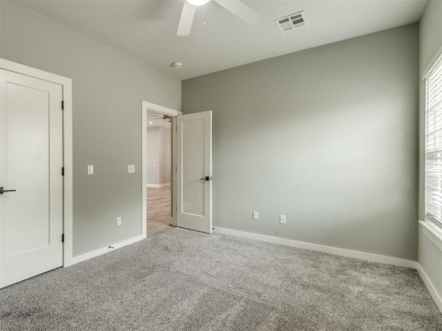 8520 NW 123rd St, Oklahoma City, OK 73142 - unfurnished bedroom with carpet floors, multiple windows, and ceiling fan