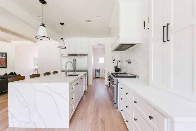 416 Old Creek Rd, Edmond, OK 73034 - kitchen featuring high end appliances, custom range hood, light wood-style flooring, backsplash, and white cabinetry