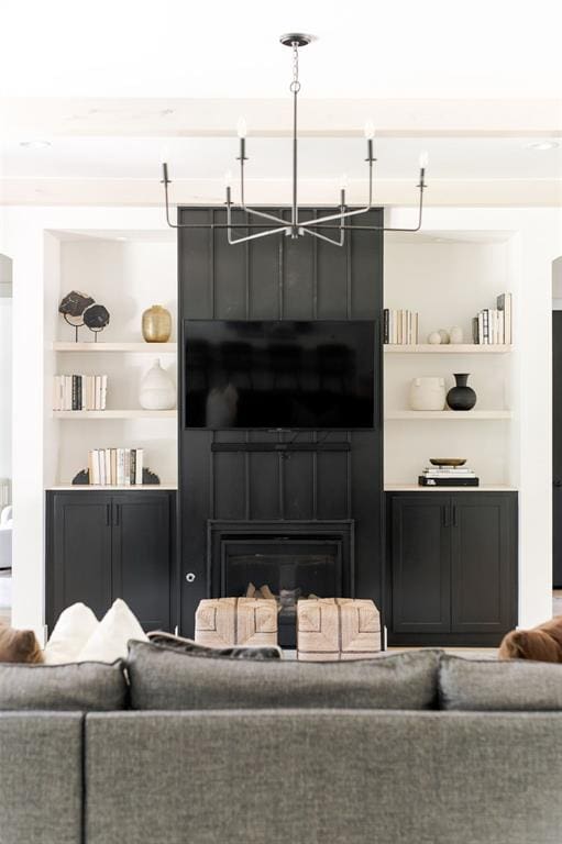 416 Old Creek Rd, Edmond, OK 73034 - living area featuring built in shelves, a fireplace, and a chandelier