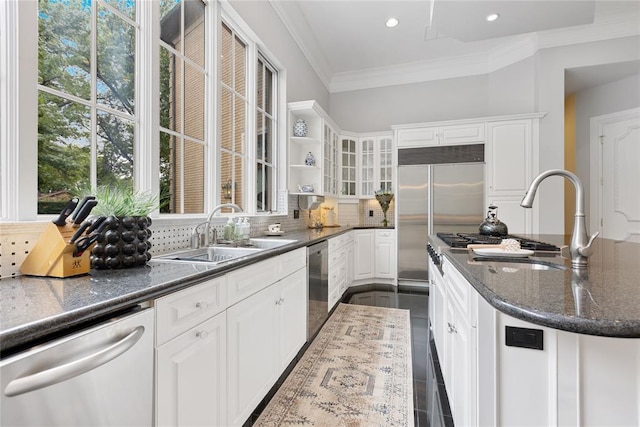 4800 Bocage Pl, Oklahoma City, OK 73142 - kitchen featuring appliances with stainless steel finishes, tasteful backsplash, crown molding, white cabinetry, and dark stone countertops