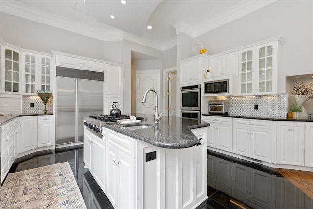 4800 Bocage Pl, Oklahoma City, OK 73142 - kitchen featuring built in appliances, tasteful backsplash, white cabinets, a center island with sink, and recessed lighting