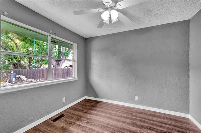 1017 Linn Ln, Yukon, OK 73099 - unfurnished room featuring a textured wall, a textured ceiling, wood finished floors, and a ceiling fan