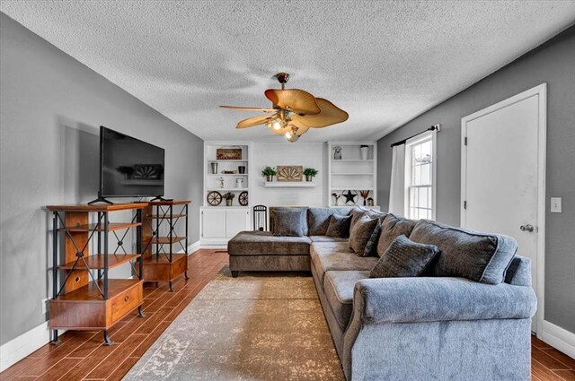 1017 Linn Ln, Yukon, OK 73099 - living room featuring wood finished floors, a ceiling fan, a textured ceiling, and built in features