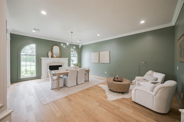 305 Carmel Valley Way, Edmond, OK 73025 - living room with recessed lighting, light wood-style flooring, a chandelier, ornamental molding, and a fireplace