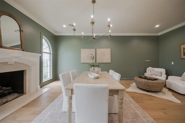 305 Carmel Valley Way, Edmond, OK 73025 - dining room featuring a chandelier, ornamental molding, wood finished floors, recessed lighting, and a premium fireplace