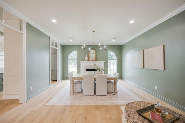 305 Carmel Valley Way, Edmond, OK 73025 - dining room featuring light wood-style flooring, a chandelier, crown molding, a premium fireplace, and recessed lighting