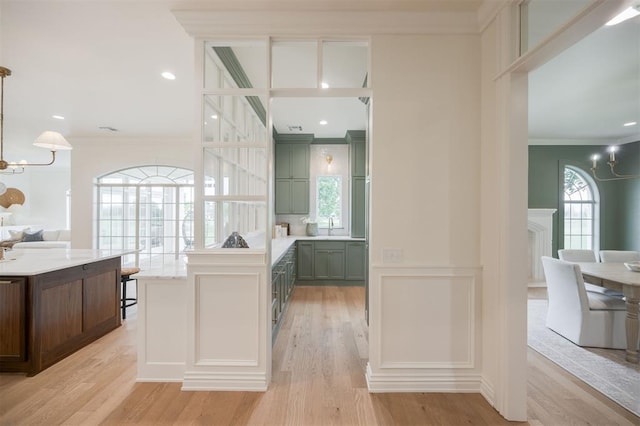 305 Carmel Valley Way, Edmond, OK 73025 - kitchen featuring a chandelier, ornamental molding, green cabinets, light wood-style floors, and light countertops