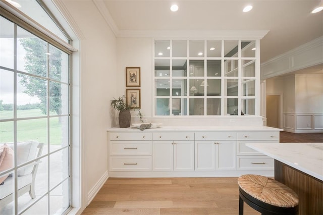 305 Carmel Valley Way, Edmond, OK 73025 - kitchen featuring crown molding, light wood-style floors, white cabinets, light stone counters, and recessed lighting