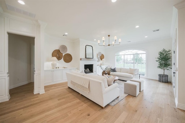 305 Carmel Valley Way, Edmond, OK 73025 - living room with crown molding, light wood finished floors, ornate columns, a fireplace, and recessed lighting
