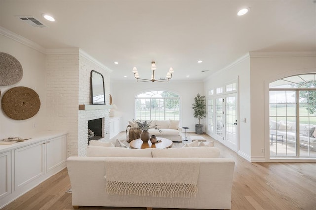 305 Carmel Valley Way, Edmond, OK 73025 - living room featuring light wood-style flooring, a brick fireplace, recessed lighting, a chandelier, and ornamental molding