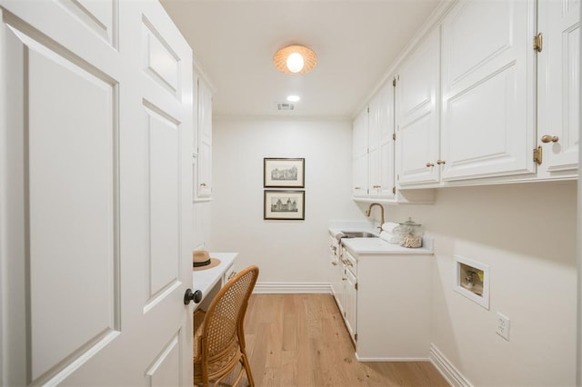 305 Carmel Valley Way, Edmond, OK 73025 - laundry room featuring light wood-style floors, cabinet space, and washer hookup