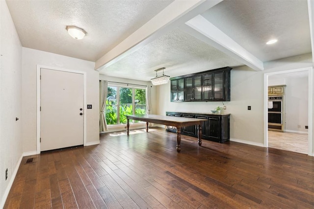 4424 Brighton Ct, Norman, OK 73072 - entryway featuring a textured ceiling, beam ceiling, and dark wood-type flooring