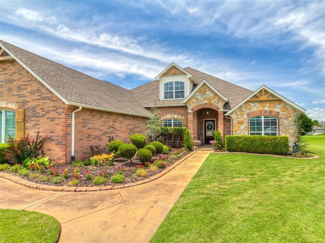 7821 Lindsay Ln, Edmond, OK 73025 - traditional home with stone siding, a front yard, a shingled roof, and brick siding