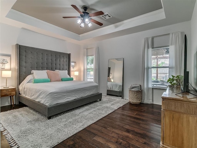 7821 Lindsay Ln, Edmond, OK 73025 - bedroom with a raised ceiling, dark wood-type flooring, multiple windows, ornamental molding, and ceiling fan