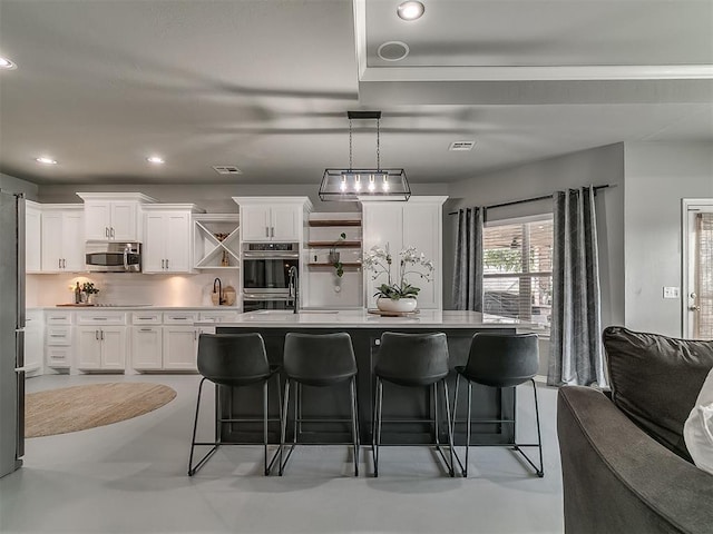 7821 Lindsay Ln, Edmond, OK 73025 - kitchen with stainless steel appliances, a kitchen bar, light countertops, white cabinetry, and recessed lighting
