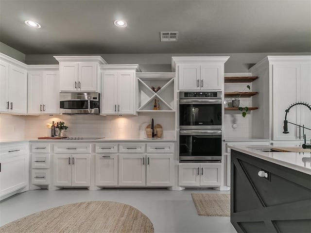 7821 Lindsay Ln, Edmond, OK 73025 - kitchen with open shelves, stainless steel appliances, decorative backsplash, and recessed lighting