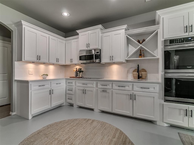 7821 Lindsay Ln, Edmond, OK 73025 - kitchen featuring stainless steel appliances, open shelves, white cabinets, tasteful backsplash, and light countertops