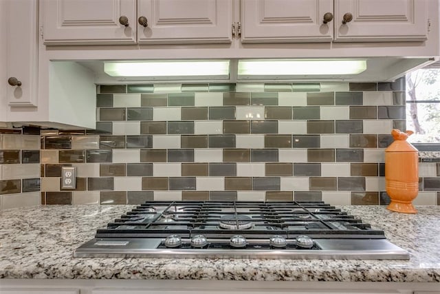 10116 Thompson Ave, Yukon, OK 73099 - kitchen view of stainless steel gas stovetop, tasteful backsplash, white cabinetry, and light stone countertops