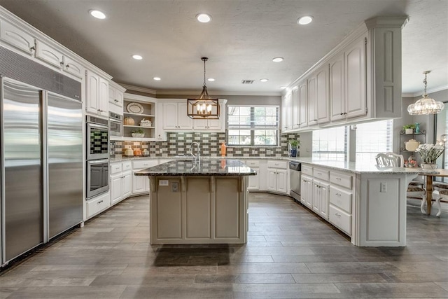 10116 Thompson Ave, Yukon, OK 73099 - kitchen with stainless steel appliances, a chandelier, open shelves, ornamental molding, and backsplash