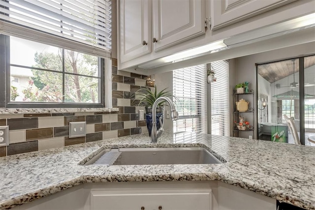 10116 Thompson Ave, Yukon, OK 73099 - kitchen view of tasteful backsplash, white cabinetry, and light stone countertops