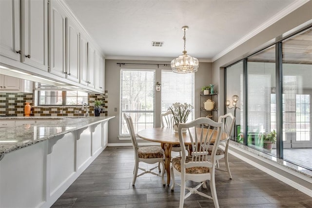 10116 Thompson Ave, Yukon, OK 73099 - dining space featuring plenty of natural light, a chandelier, crown molding, and dark wood-style floors