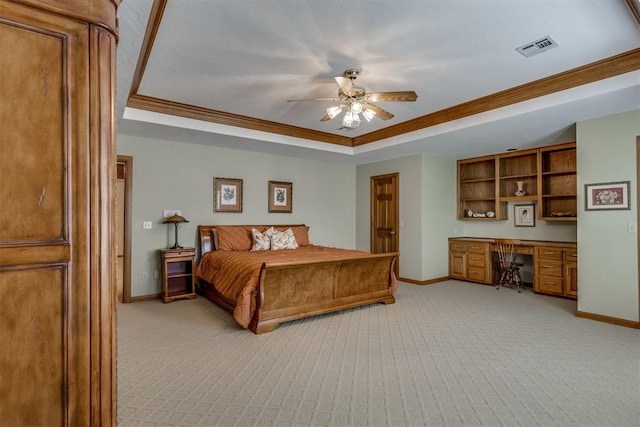 10116 Thompson Ave, Yukon, OK 73099 - bedroom with a raised ceiling, built in desk, light colored carpet, crown molding, and ceiling fan