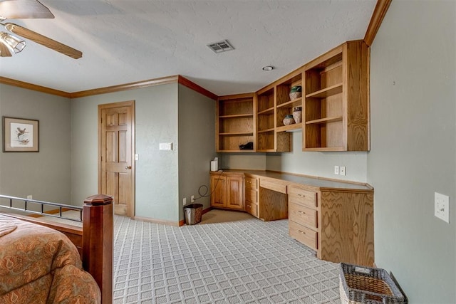 10116 Thompson Ave, Yukon, OK 73099 - bedroom featuring built in study area, light colored carpet, ornamental molding, and ceiling fan