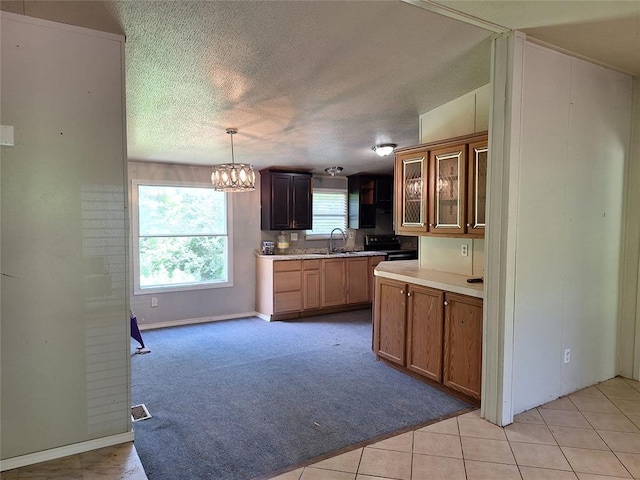 18451 Rolling Oak Rd, Newalla, OK 74857 - kitchen featuring a chandelier, light countertops, a textured ceiling, glass insert cabinets, and light colored carpet