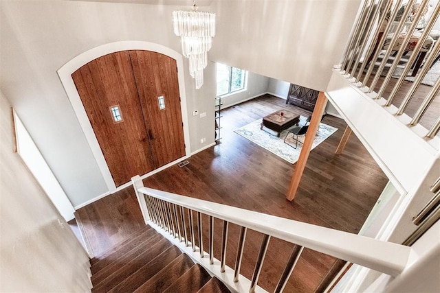 6540 S Donna Ln, Oklahoma City, OK 73150 - stairs with arched walkways, wood finished floors, and a chandelier