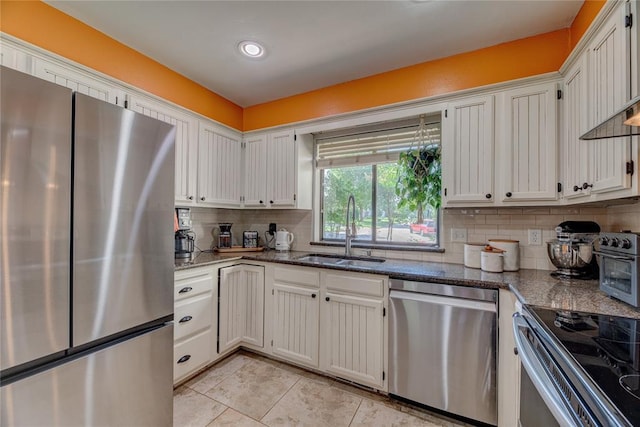 6348 Hyde Park Dr, Oklahoma City, OK 73162 - kitchen with stainless steel appliances, tasteful backsplash, light tile patterned floors, dark stone countertops, and white cabinets