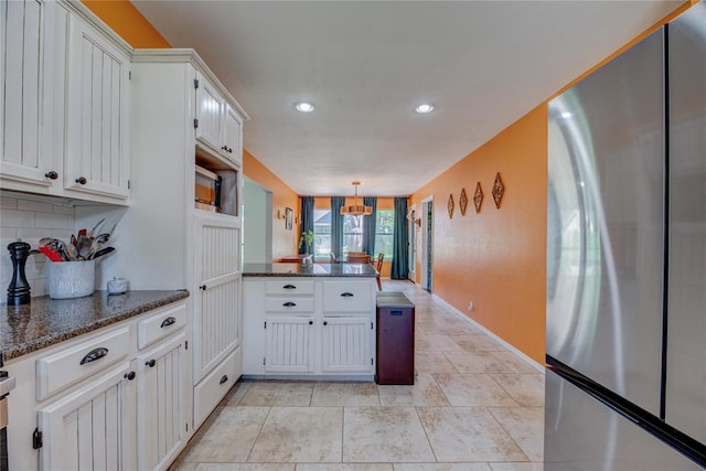 6348 Hyde Park Dr, Oklahoma City, OK 73162 - kitchen with freestanding refrigerator, a peninsula, recessed lighting, backsplash, and white cabinets
