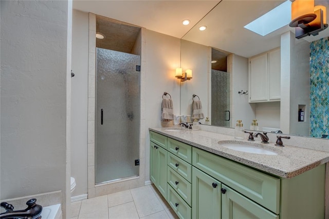 6348 Hyde Park Dr, Oklahoma City, OK 73162 - bathroom featuring a skylight, double vanity, a shower stall, tile patterned flooring, and recessed lighting
