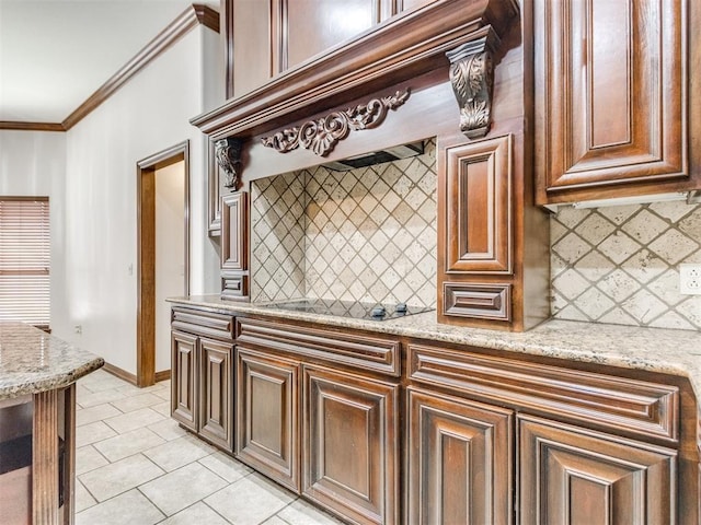 17104 Wales Green Ave, Edmond, OK 73012 - kitchen with light tile patterned floors, ornamental molding, decorative backsplash, black electric stovetop, and light stone countertops