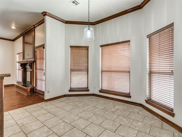 17104 Wales Green Ave, Edmond, OK 73012 - unfurnished dining area featuring ornamental molding, light tile patterned floors, and a fireplace with raised hearth