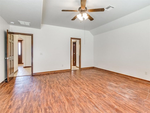 17104 Wales Green Ave, Edmond, OK 73012 - unfurnished room featuring light wood-style flooring, a ceiling fan, and arched walkways