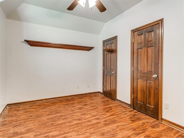 17104 Wales Green Ave, Edmond, OK 73012 - unfurnished bedroom with wood finished floors, vaulted ceiling, and ceiling fan