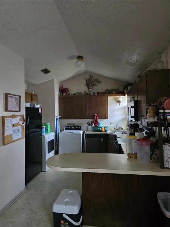 618 Briarwood Ln, Frederick, OK 73542 - kitchen featuring freestanding refrigerator, a textured ceiling, a peninsula, washer and dryer, and lofted ceiling