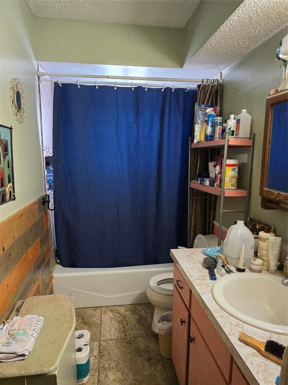 618 Briarwood Ln, Frederick, OK 73542 - full bath with vanity, shower / tub combo, a textured ceiling, and stone finish flooring