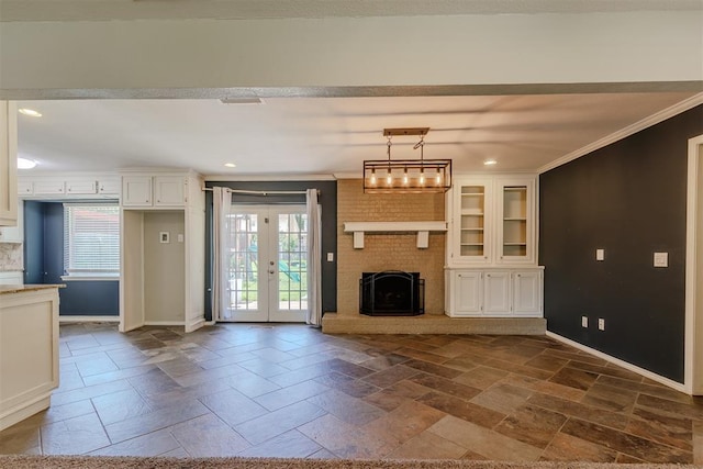 5717 NW 31st Ter, Oklahoma City, OK 73122 - unfurnished living room with crown molding, stone tile floors, plenty of natural light, recessed lighting, and french doors