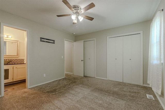 5717 NW 31st Ter, Oklahoma City, OK 73122 - unfurnished bedroom featuring light carpet, two closets, connected bathroom, and ceiling fan