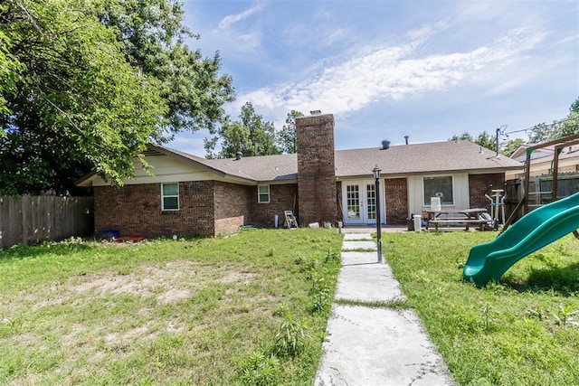 5717 NW 31st Ter, Oklahoma City, OK 73122 - rear view of house with french doors, a playground, a chimney, and brick siding