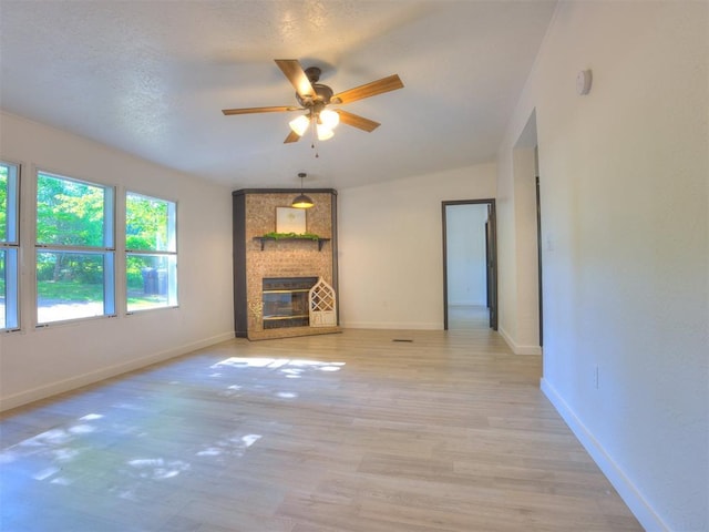 9200 Hollow Rd, Newalla, OK 74857 - unfurnished living room with a ceiling fan, light wood finished floors, and a fireplace